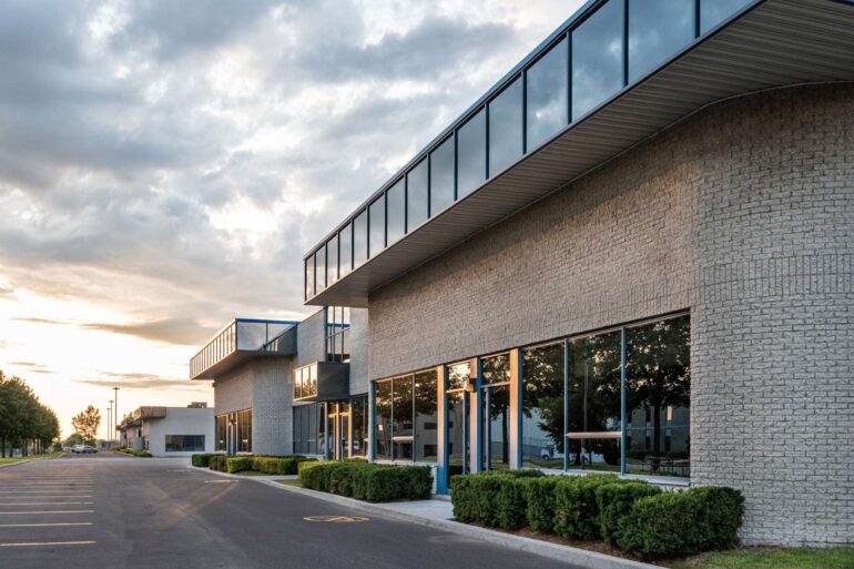 he exterior of a small business and parking lot. The building features modern architecture and professional landscaping.