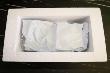 An open white Styrofoam container with no lid. Inside the container is a white, crumpled up ice pack.