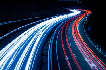 Red and blue streaks from car lights on a highway revealed using a long exposure camera technique.