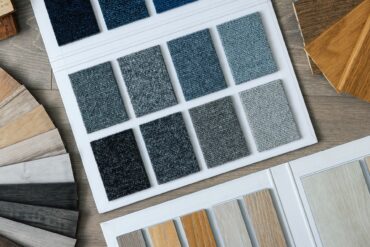 A collection of different tile samples and swatches in different shades and textures. The squares are attached to a board.